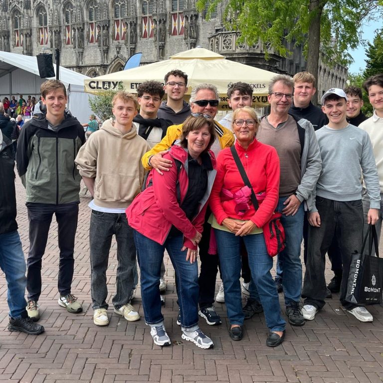 Gruppe von Jugendlichen in blauen Sportshirts vor einem Tischtenniszentrum. Gruppe von Jugendlichen in blauen Sportshirts vor einem Tischtenniszentrum.